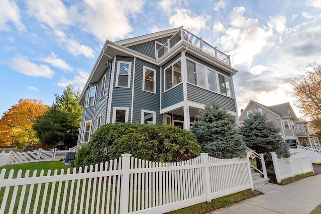 view of front of property featuring a fenced front yard and a balcony