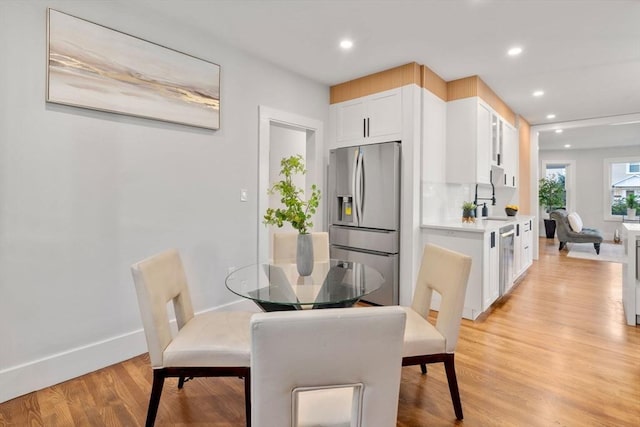 dining room with recessed lighting, baseboards, and light wood finished floors