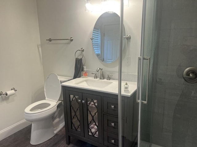 full bathroom featuring a shower stall, baseboards, toilet, wood finished floors, and vanity