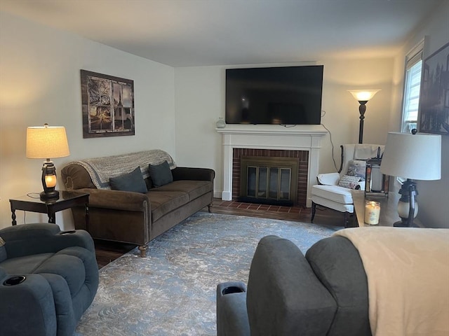 living area with a brick fireplace and wood finished floors