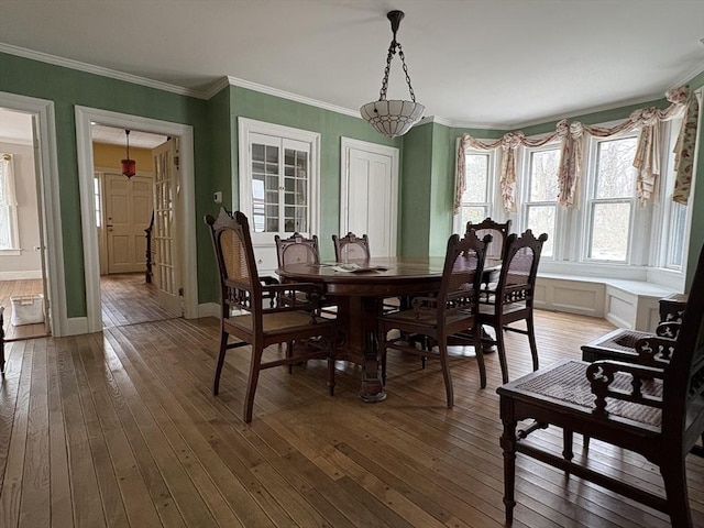 dining room with baseboards, light wood-style flooring, and crown molding