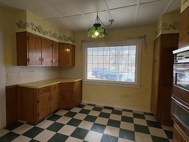 kitchen with light floors, brown cabinetry, and light countertops