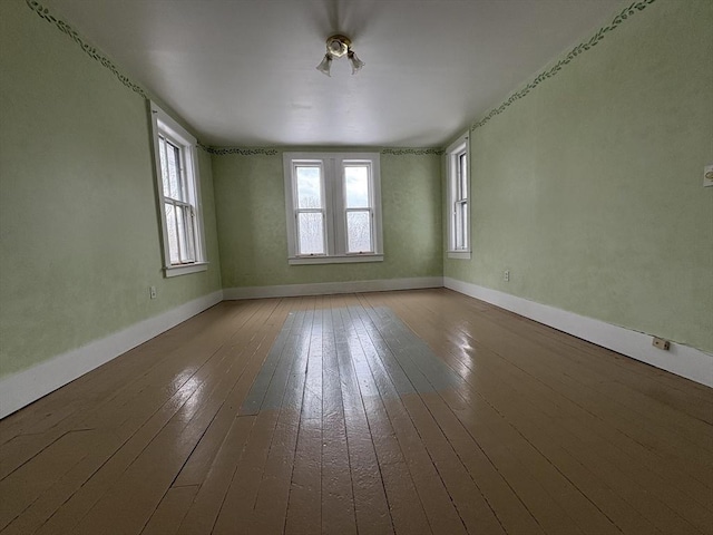 empty room featuring hardwood / wood-style flooring and baseboards