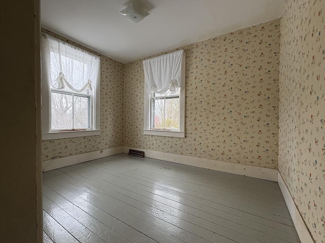 spare room featuring a wealth of natural light, hardwood / wood-style floors, and wallpapered walls