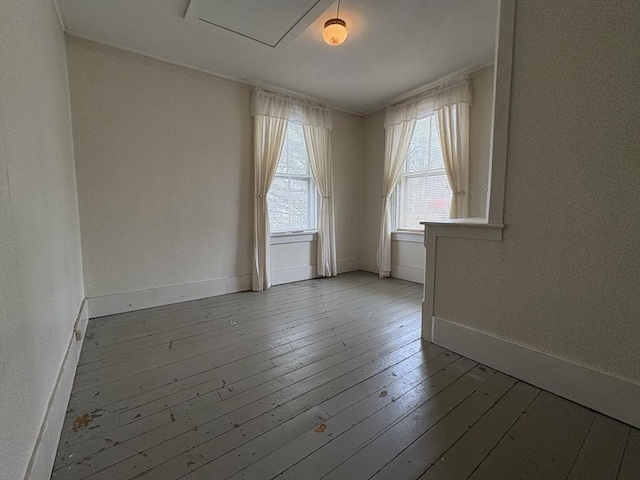 spare room featuring baseboards and wood-type flooring