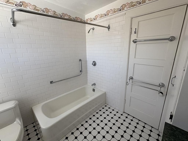 full bath featuring toilet, tile walls, and washtub / shower combination