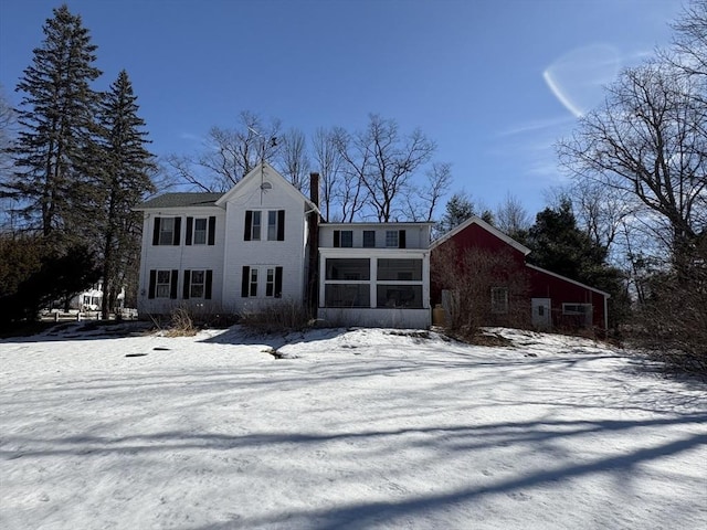 view of front facade with a chimney and a sunroom