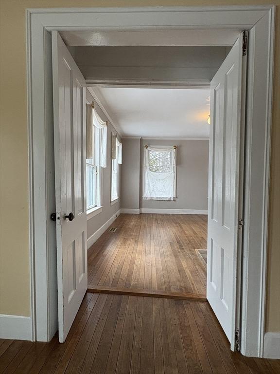 corridor featuring dark wood-style floors and baseboards