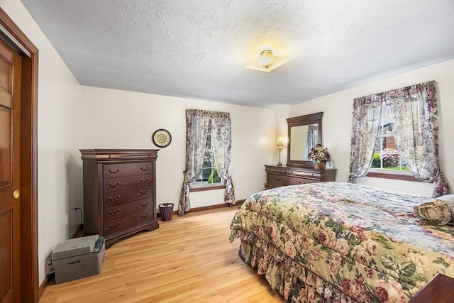 19 K St, Weymouth, MA 02189 - bedroom featuring light wood-style floors, baseboards, and a textured ceiling
