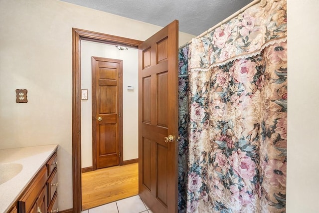19 K St, Weymouth, MA 02189 - bathroom featuring vanity, tile patterned flooring, a shower with shower curtain, baseboards, and a textured ceiling