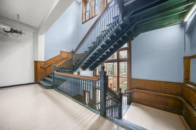 235 State St Unit 317, Springfield, MA 01103 - stairs featuring wooden walls, wainscoting, tile patterned floors, and healthy amount of natural light