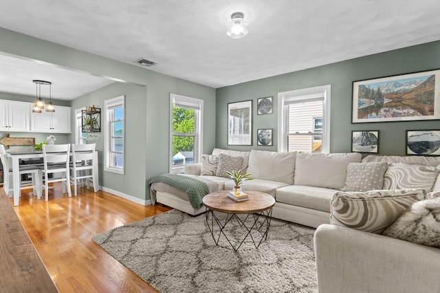 353 Medford St Unit 2, Malden, MA 02148 - living area with light wood-style flooring, plenty of natural light, baseboards, and a chandelier