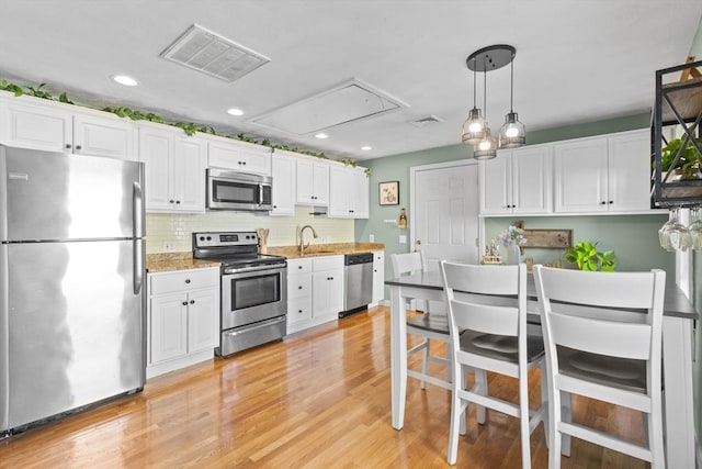 353 Medford St Unit 2, Malden, MA 02148 - kitchen featuring stainless steel appliances, white cabinetry, light wood finished floors, a sink, and recessed lighting