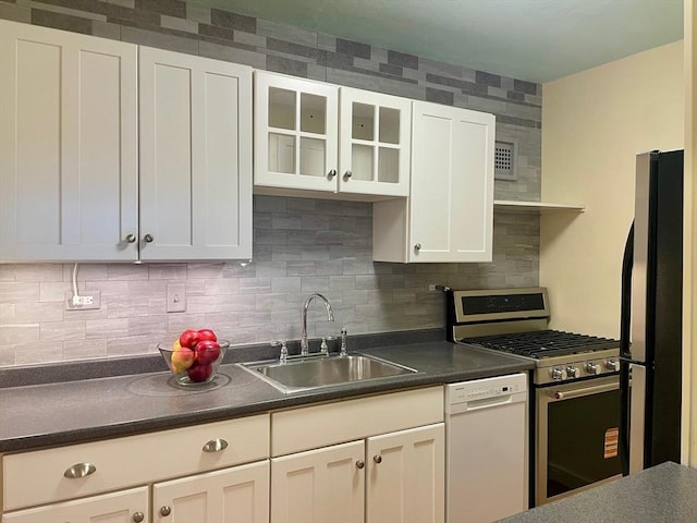 6 Whittier Pl Unit 15H, Boston, MA 02114 - kitchen featuring appliances with stainless steel finishes, dark countertops, white cabinetry, decorative backsplash, and glass insert cabinets