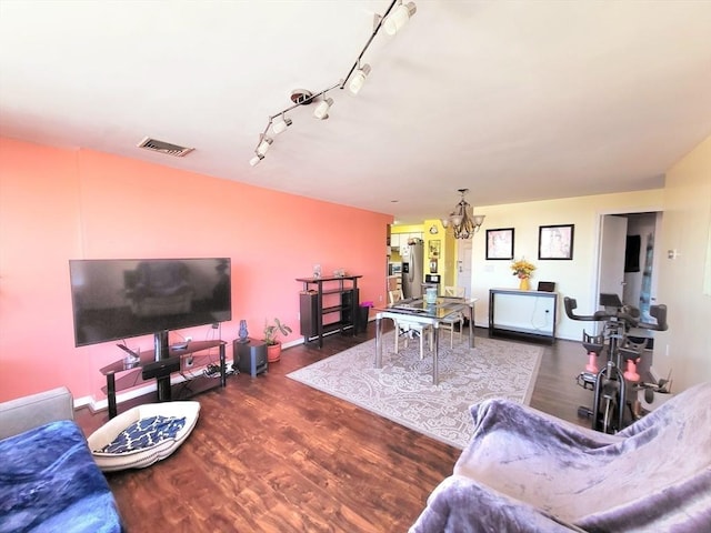 living room with a notable chandelier and dark wood-type flooring