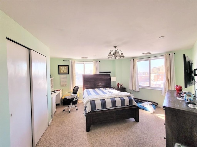 carpeted bedroom featuring an inviting chandelier and a closet