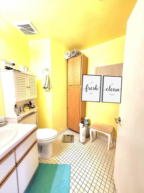 bathroom with tile patterned flooring, vanity, and toilet