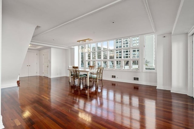 dining room with dark hardwood / wood-style floors and an inviting chandelier