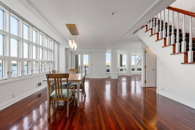 dining area with a notable chandelier, a healthy amount of sunlight, dark hardwood / wood-style floors, and ornamental molding