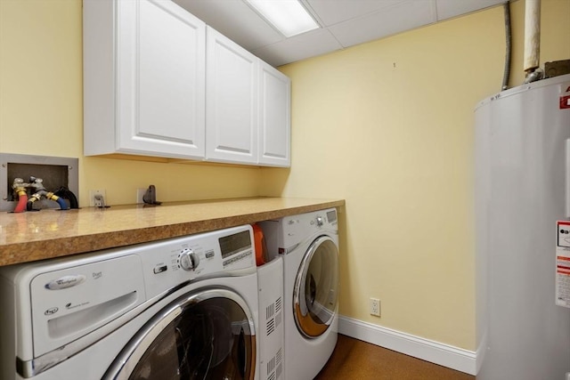 laundry room featuring washing machine and clothes dryer, water heater, and cabinets