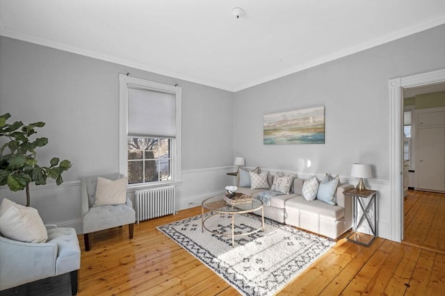 living room featuring radiator heating unit, crown molding, and wood-type flooring