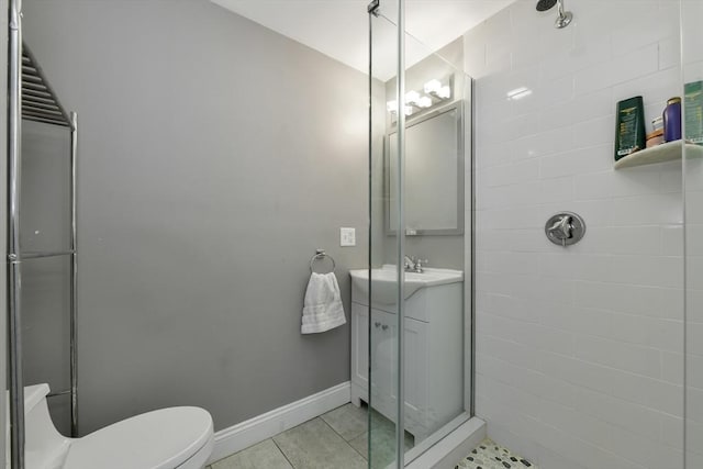 bathroom featuring toilet, a shower with shower door, and tile patterned flooring