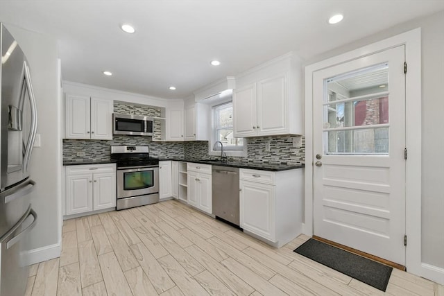 kitchen featuring sink, decorative backsplash, stainless steel appliances, and white cabinets