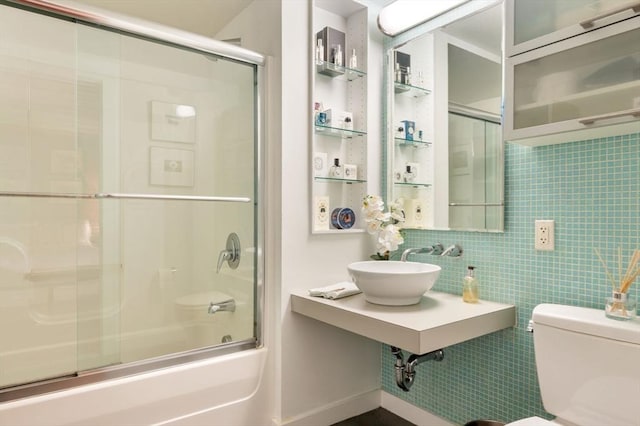 full bathroom featuring toilet, shower / bath combination with glass door, a sink, and backsplash