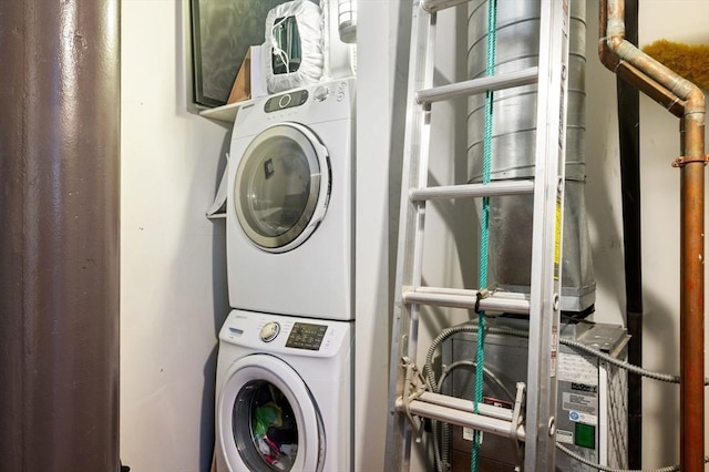 clothes washing area with stacked washer / dryer