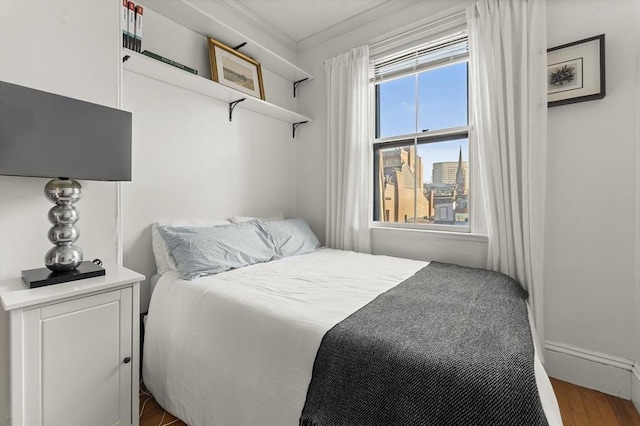 bedroom featuring wood finished floors and ornamental molding