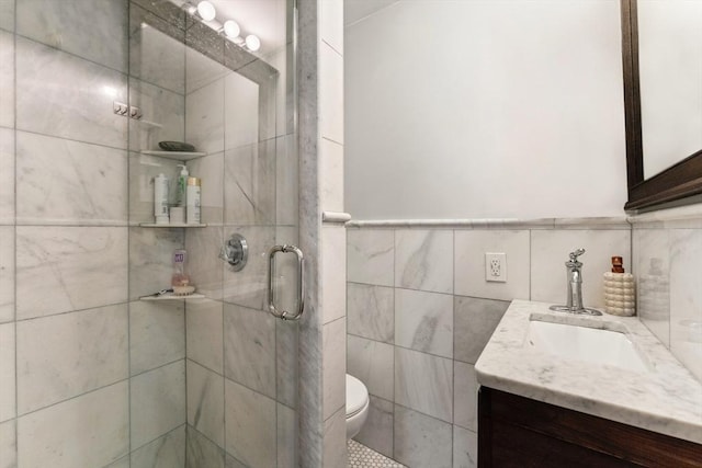 full bath featuring vanity, tile walls, a shower stall, and toilet