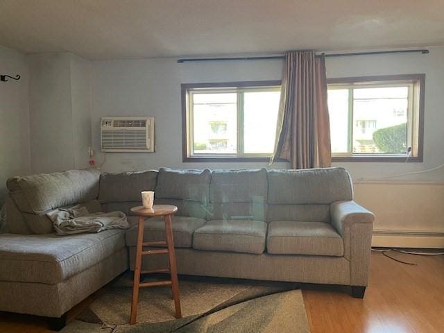 living room featuring a wall unit AC, wood finished floors, and a baseboard radiator