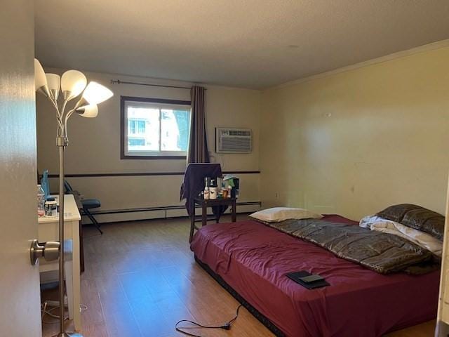 bedroom featuring crown molding, an AC wall unit, a baseboard heating unit, and wood finished floors