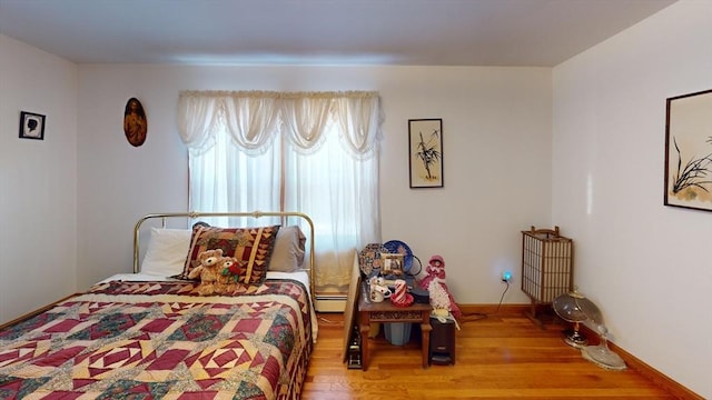 bedroom featuring wood-type flooring and baseboard heating