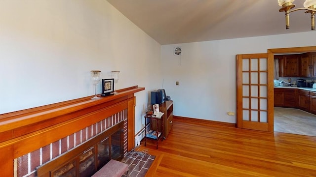 interior space featuring a tiled fireplace, light hardwood / wood-style flooring, and a baseboard radiator