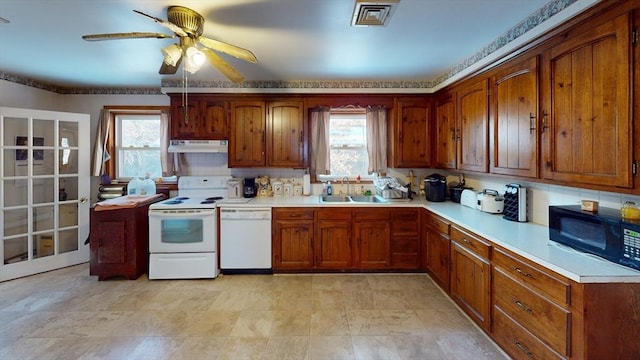 kitchen featuring tasteful backsplash, white appliances, a healthy amount of sunlight, and sink