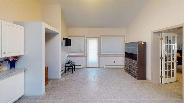 kitchen featuring white cabinetry, vaulted ceiling, and a baseboard heating unit