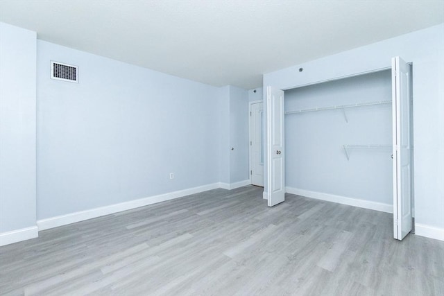 unfurnished bedroom with a closet and light hardwood / wood-style flooring