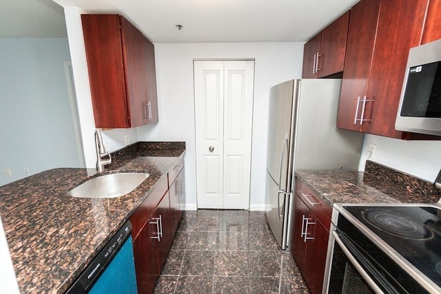 kitchen with dark stone counters, sink, and stainless steel appliances