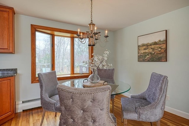 dining room with a chandelier, wood finished floors, baseboards, and baseboard heating