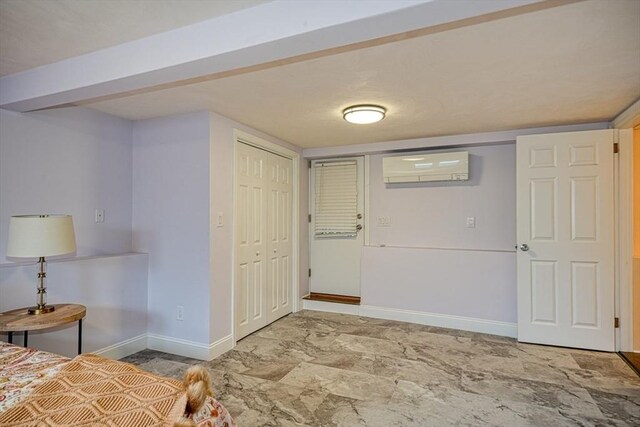 unfurnished bedroom featuring a closet, an AC wall unit, and baseboards