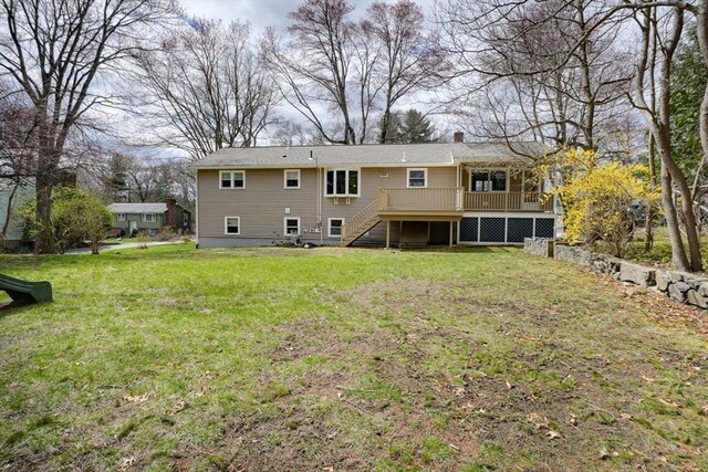 rear view of property featuring a lawn, a wooden deck, stairway, and a chimney