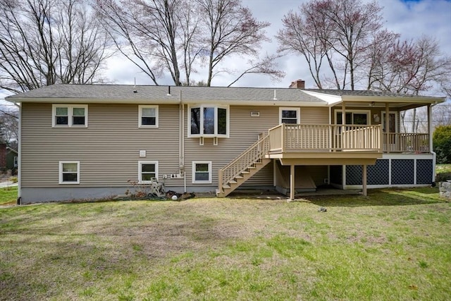 back of house featuring a chimney, a yard, stairs, and a deck