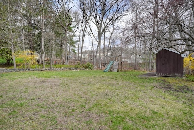 view of yard featuring a storage unit, an outdoor structure, and a playground