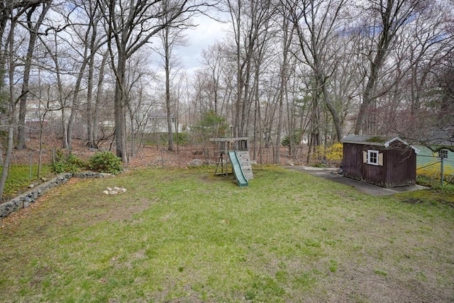 view of yard featuring an outdoor structure, a storage unit, and fence