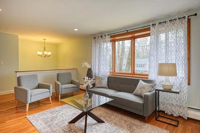 living room featuring baseboards, a notable chandelier, wood finished floors, and recessed lighting