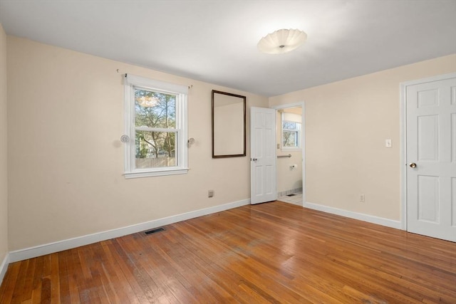 unfurnished bedroom featuring visible vents, baseboards, and hardwood / wood-style floors