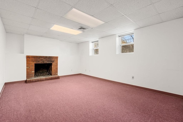 basement featuring visible vents, baseboards, a brick fireplace, and carpet flooring