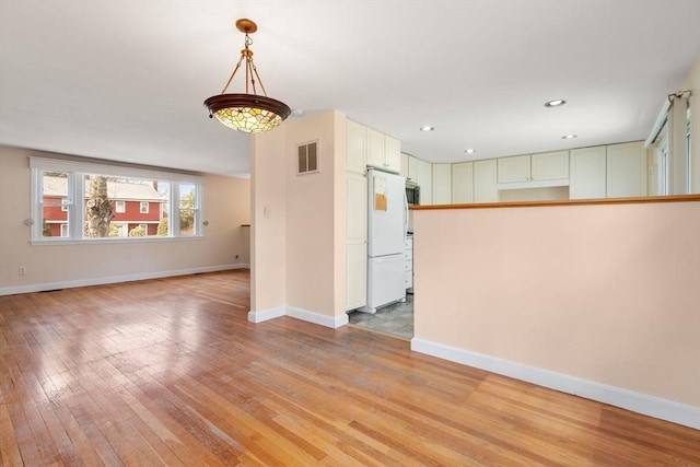 spare room featuring recessed lighting, light wood-style floors, visible vents, and baseboards