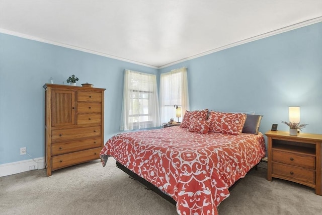 carpeted bedroom with crown molding and baseboards